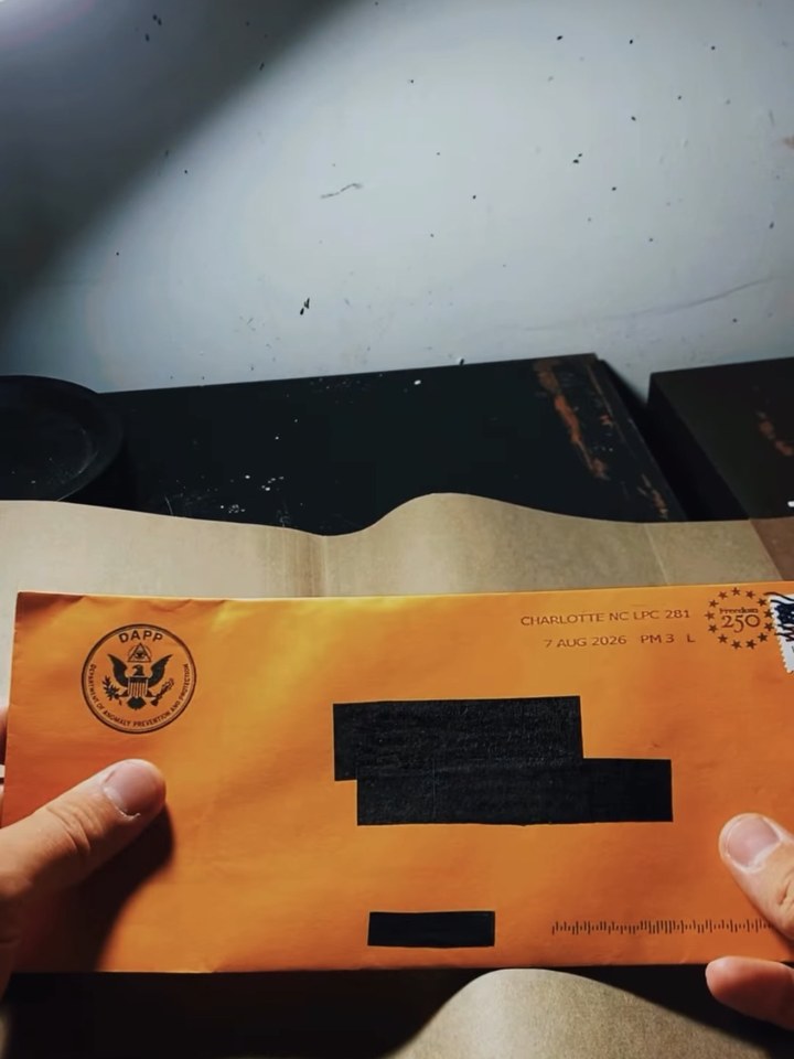 A supporter holding the DAPP envelope that carried OPEN DOOR clue #1, their address blacked out
